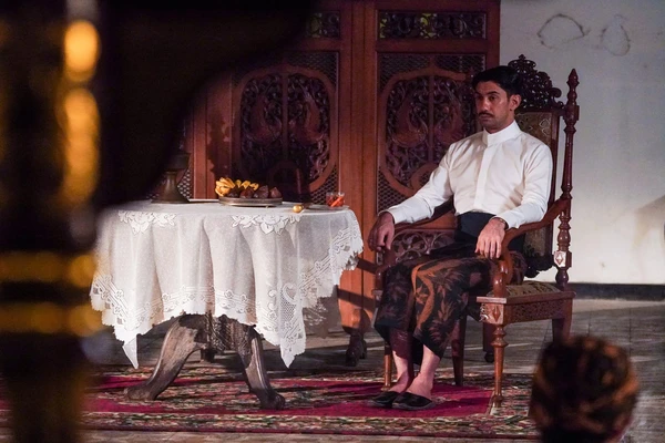 Man sits in ornate chair in "Gowok: Javanese Kamasutra".