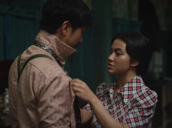 A woman adjusts a man's clothes in "Perang Kota".