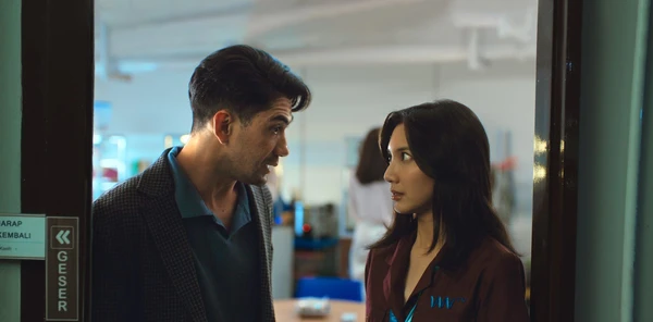 A man and a woman appear to be in a heated discussion at a doorway in The Most Beautiful Girl in the World.
